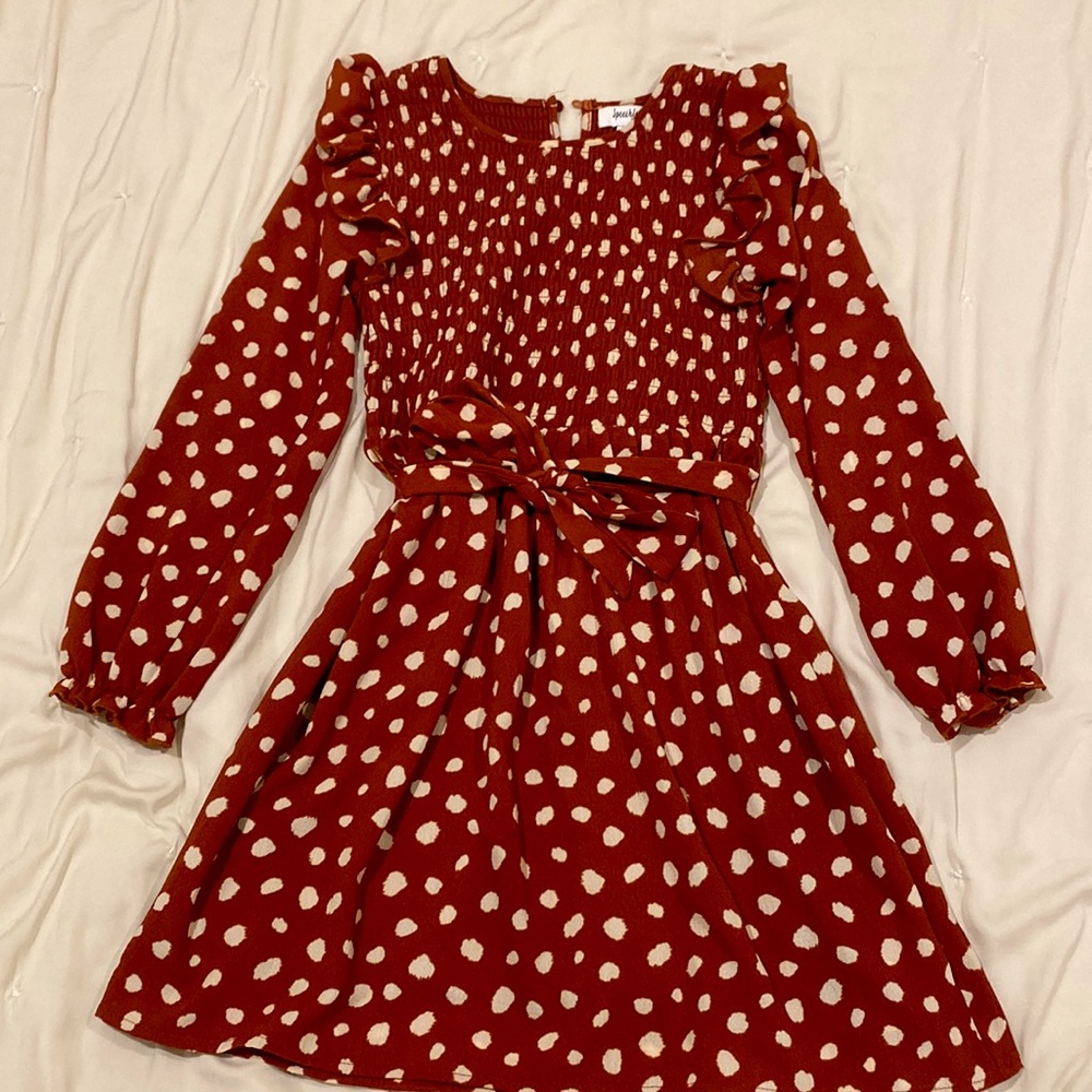 A red children’s dress with polka dots that exudes a fun yet classic charm!